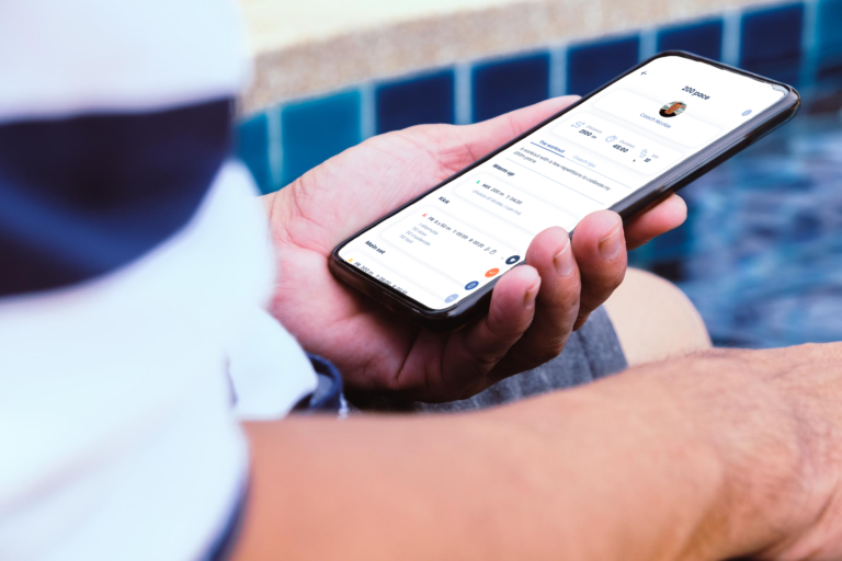 Mockup of a person holding a phone and the OpenSwim app opened